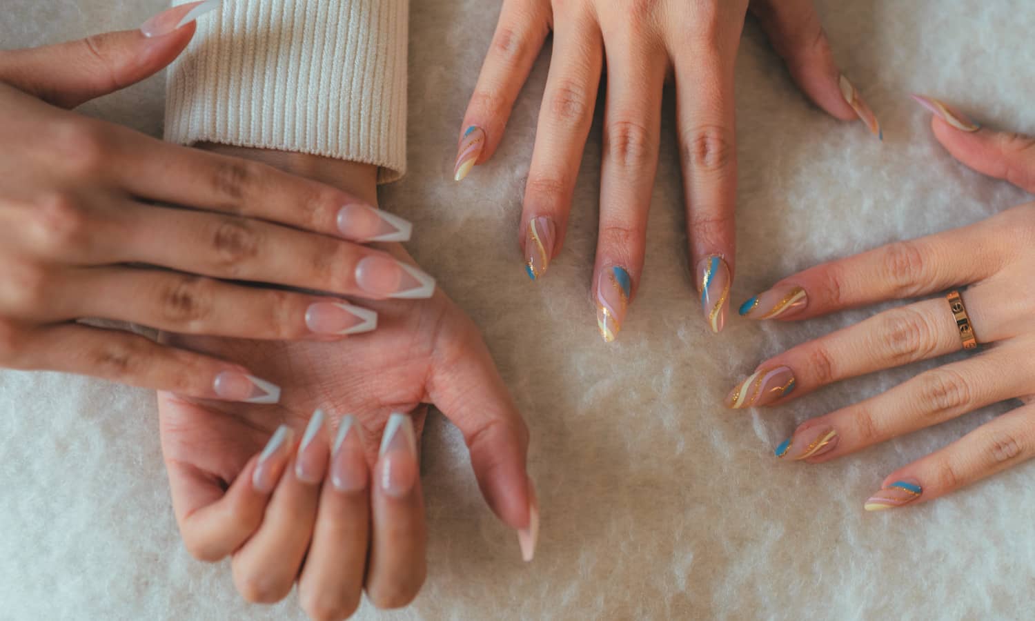 two pairs of hands wearing pink press on nails sets after applying