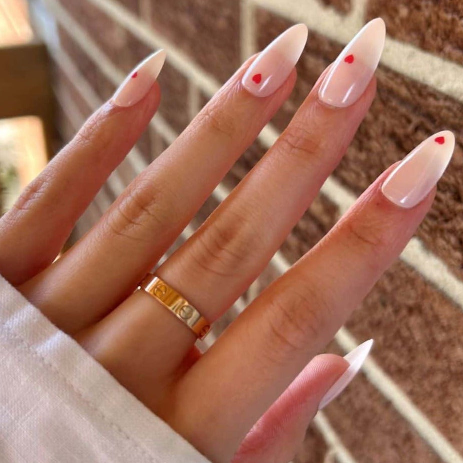 light pink nails with mini red hearts