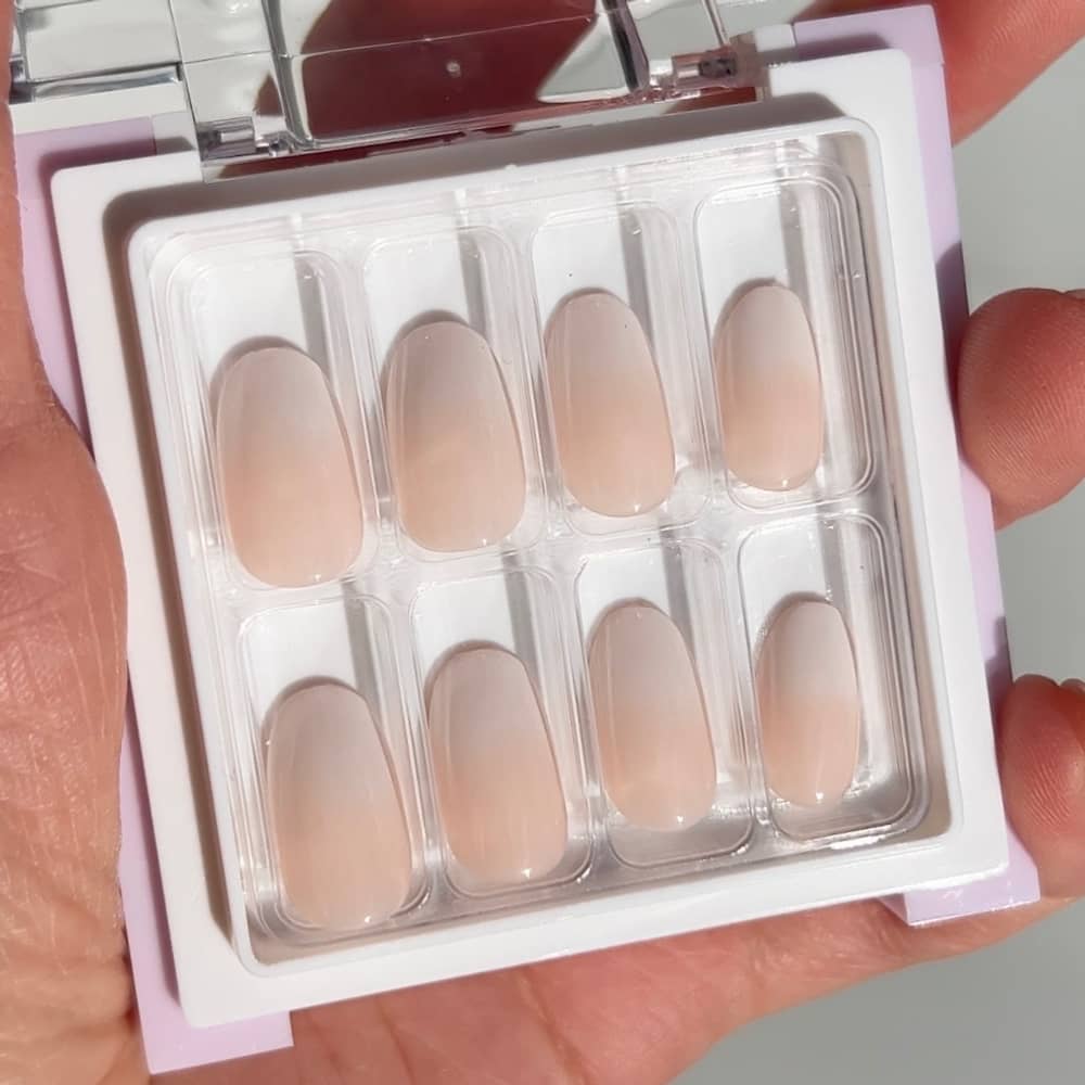 light pink blush ombre press on nails on female hand short length round shape