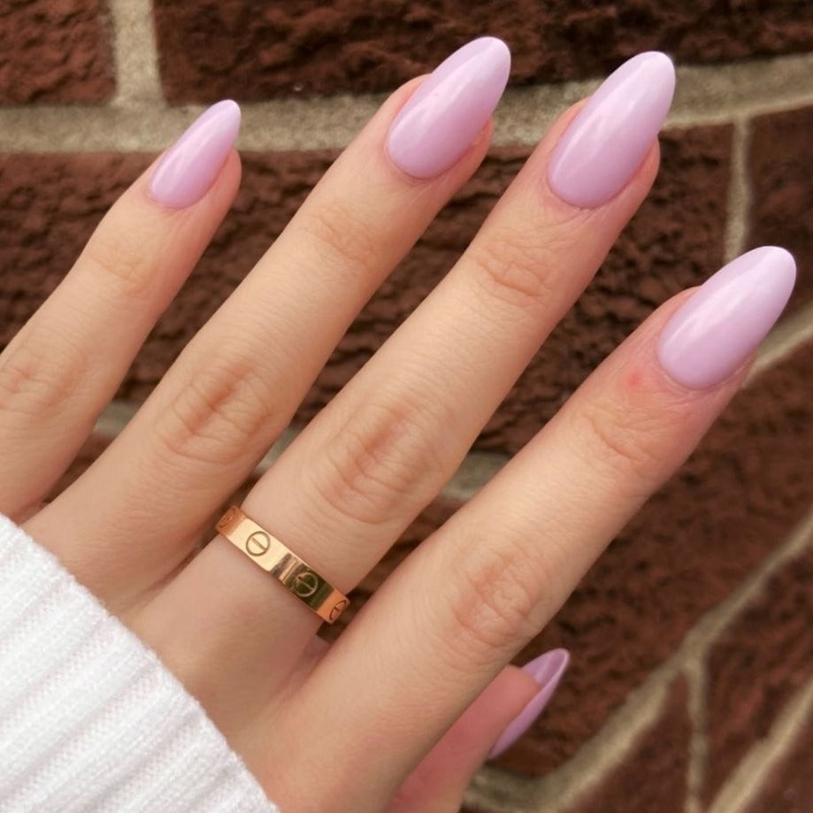 female hand wearing lilac press on nails in almond shape and medium length