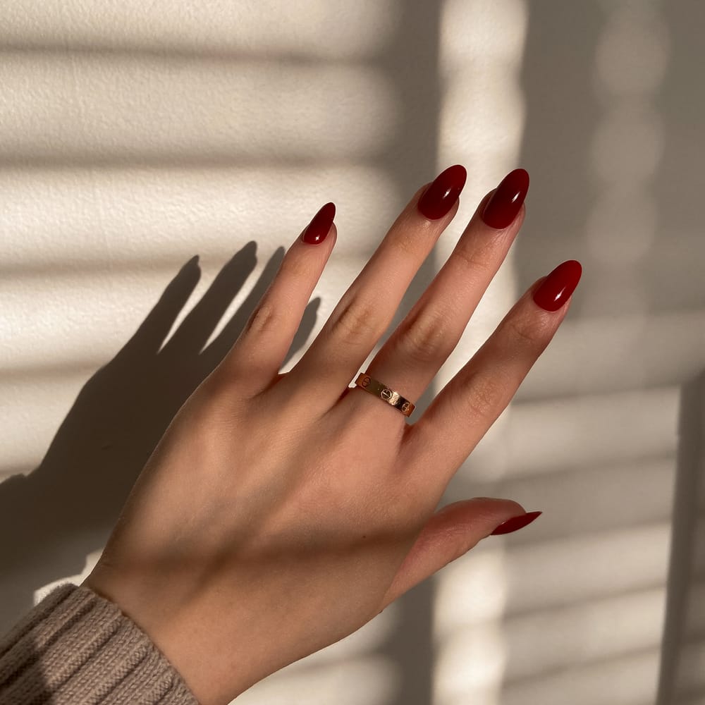 female-hand-wearing-red-almond-press-on-nails